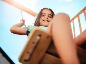 criança se divertindo em balanço em playground para condominio