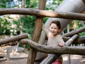 Criança brincando em um parque de madeira